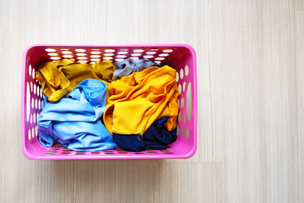 Close up empty business card on clothes and white fabric in basket with washing machine background. Laundry concept.