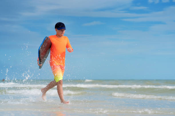 istock Kid with skimboard on a beach in Miami 1263285056