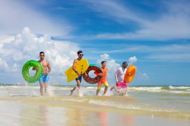 istock Running with inflatable ring tubes on a beach in Miami 1263285595