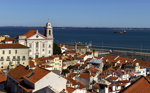 Lisbon, Portugal, March 14, 2019: View of the Saint Stephen Church (Portuguese: Igreja de Santo Estêvão) which is a catholic church in Alfama district. It is classified as a National Monument. Tagus River in the background.