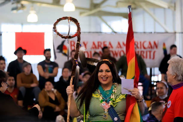 native american dwóch duchowych osób posiada tradycyjny grand entry orzeł pracowników i tęczową flagę w powwow, san francisco - indian flag zdjęcia i obrazy z banku zdjęć
