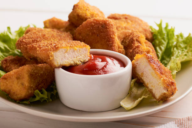 istock Breaded chicken nuggets in a plate with ketchup and lettuce 1263295082