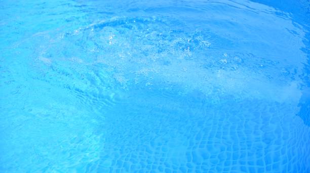 istock Blue water in swimming pool with sun reflection. 1263307539