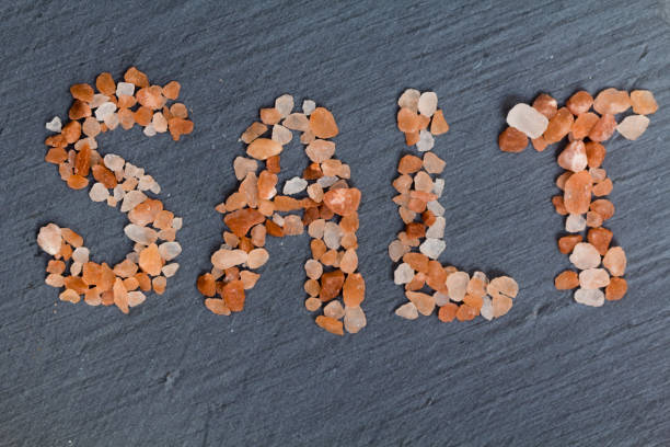 Himalayan salt used to write the word salt which is places on a slate background.