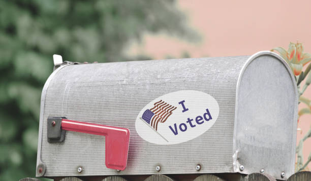 Metal mailbox for rural homes with I Voted sticker as concept for voting by mail or absentee ballot paper Metal mailbox for rural homes with I Voted sticker as concept for voting by mail or absentee ballot paper absentee ballot photos stock pictures, royalty-free photos & images