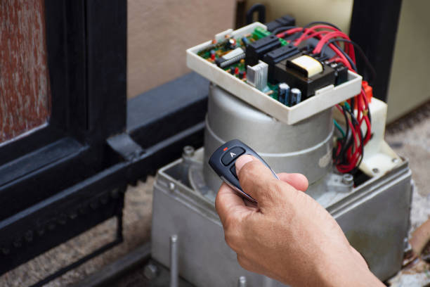 Technician man Technician man hand holding remote control, testing and checking the functional of motor gear automatic gate. Maintenance concept. thai door stock pictures, royalty-free photos & images