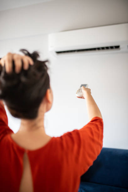 istock Woman switching on air conditioner 1263325961