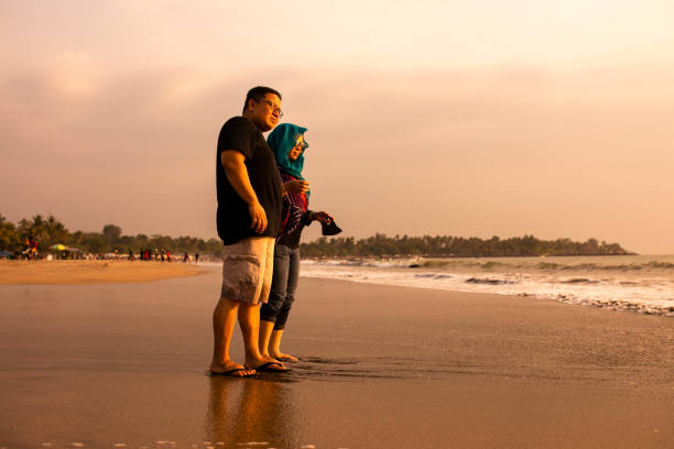 istock Happy Couple Holding Hands on Beach 1263327892