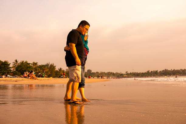 istock Happy Couple Holding Hands on Beach 1263328540