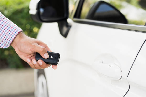 istock Close up car keys and remote control car alarm systems hold in hand 1263328600