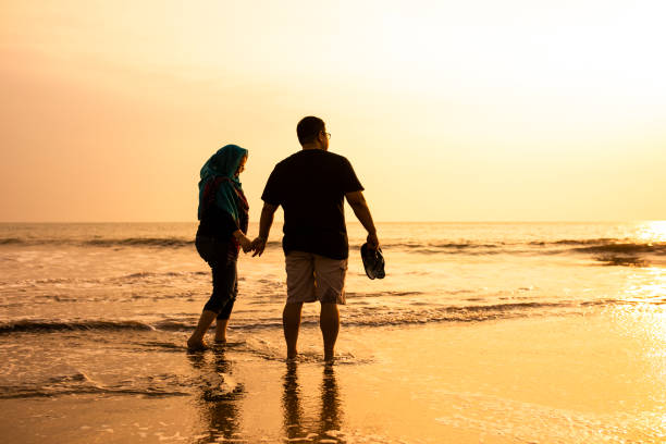 istock Happy Couple Holding Hands on Beach 1263328789
