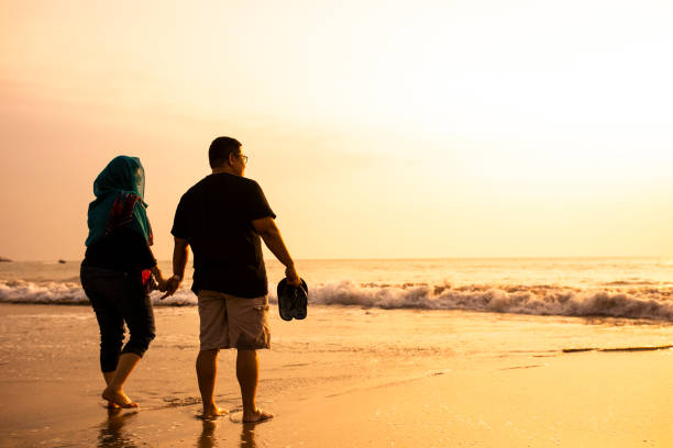 istock Happy Couple Holding Hands on Beach 1263328869