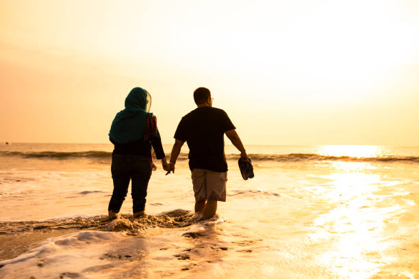 istock Happy Couple Holding Hands on Beach 1263328895