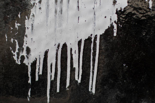 istock White paint dripping down on a dirty structured glass texture for background 1263333368