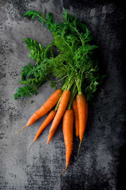 istock A bunch of fresh  organic carrots on dark background. 1263336986