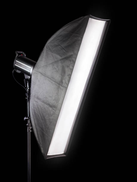 Photo studio lighting stands with flash and softbox isolated on the black. Studio lighting stands with flash and softbox isolated on the black background. Elements of professional photography equipment. searchlight photos stock pictures, royalty-free photos & images