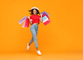 concept of shopping purchases and sales of happy   girl with packages  on yellow background