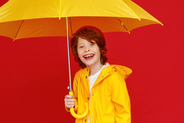 istock Funny boy with umbrella on rainy day 1263343335