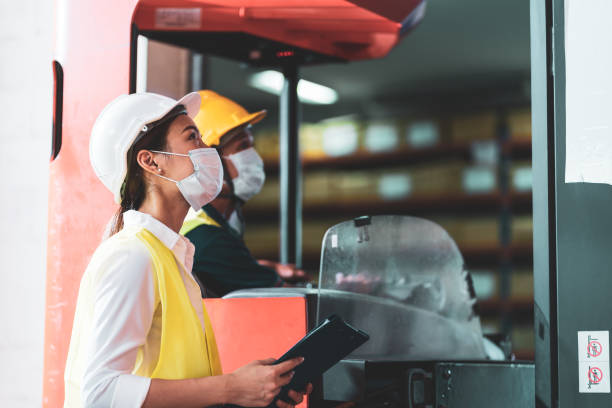 istock Asian warehouse worker wear face mask as new normal work in Covid 19 1263350686