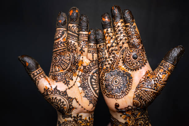 istock Human hand decorated with henna tattoo on black background 1263350700