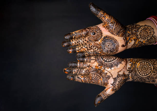istock Human hand decorated with henna tattoo on black background 1263350701