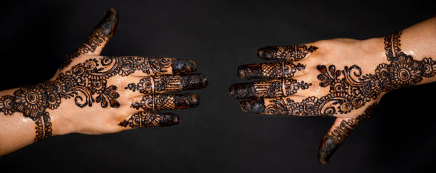 istock Human hand decorated with henna tattoo on black background 1263350725