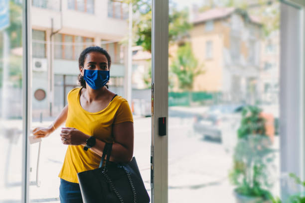 Businesswoman with protective mask during COVID-19 Businesswoman with mask is entering the office,COVID-19 concept purse photos stock pictures, royalty-free photos & images