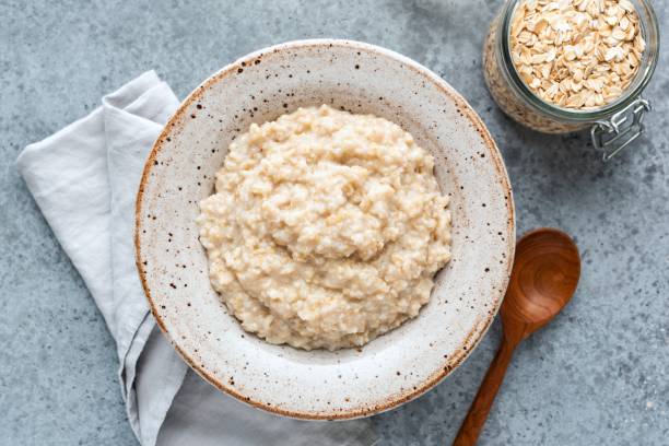 porridge di farina d'avena semplice in ciotola - oatmeal porridge bowl spoon foto e immagini stock