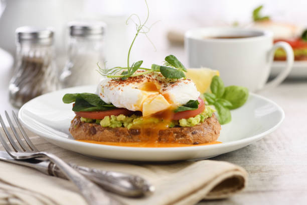 istock Breakfast. Best Eggs Benedict on a slice of toasted cereal bread with guacamole and spinach 1263354255