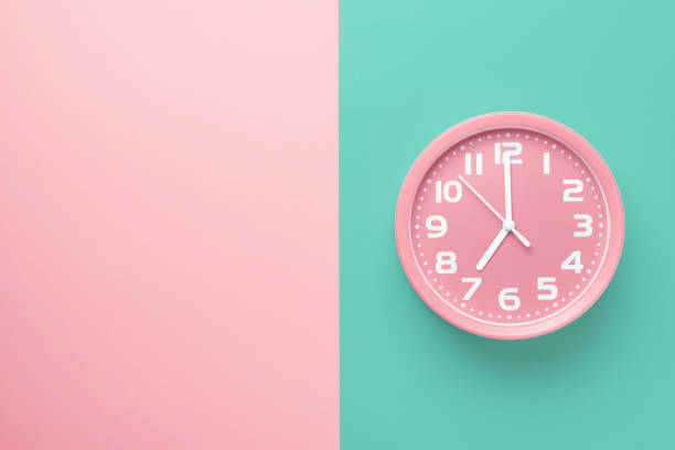 istock Pink alarm clock on a colored background divided vertically into a pink and green half with copy space 1263359927