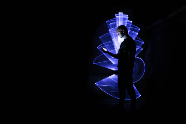 Silhouette of a man using a smartphone.