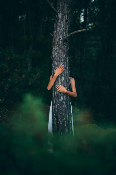 istock Young Woman Hugging a Tree at the Forest 1263361596