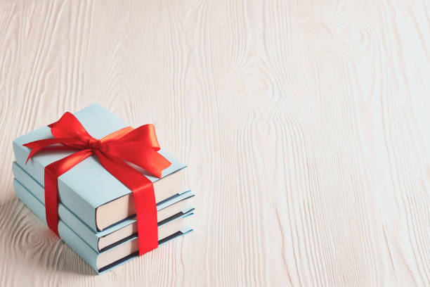 Books tied with ribbon on a wooden background with copy space: concept of donating books Books tied with ribbon on a wooden background with copy space: concept of donating books. bundle photos stock pictures, royalty-free photos & images