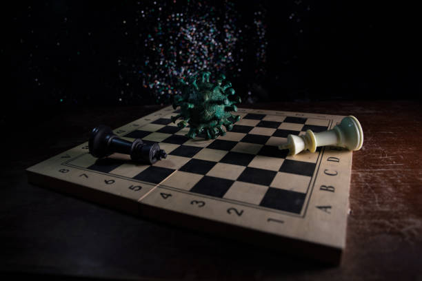 istock Big Corona virus miniature model on chessboard with fog and backlight. Creative artwork decoration. Selective focus 1263372576