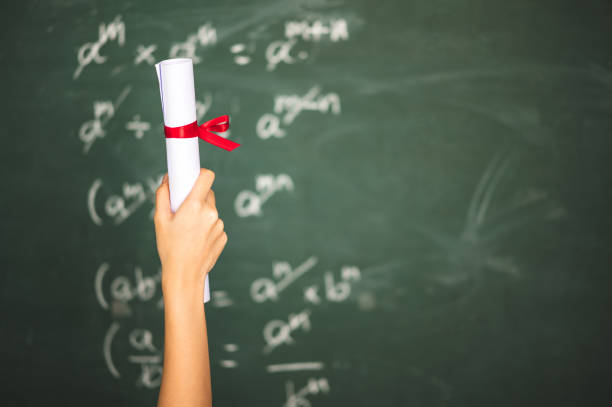 Asian female students hold a diploma in front of the class.