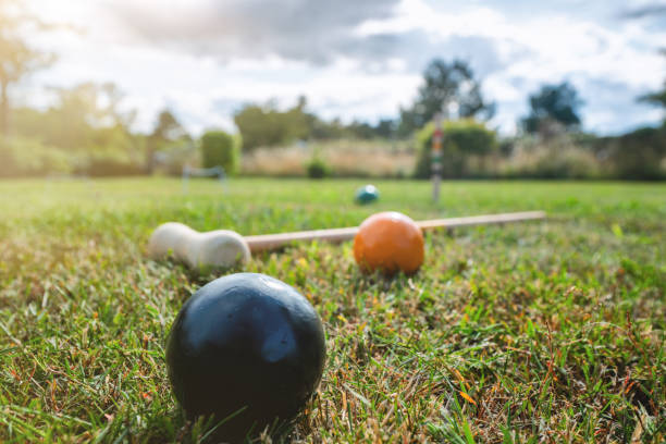 Croquet outdoor game on a lawn in the summer with a mallet and colorful balls