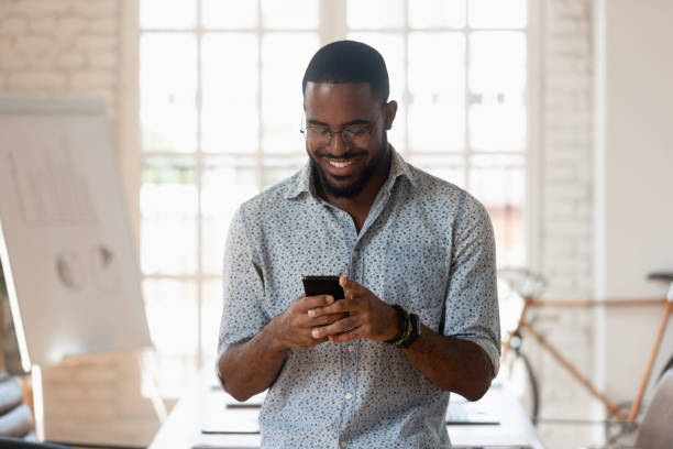istock Smiling biracial male employee using cellphone in office boardroom 1263379986