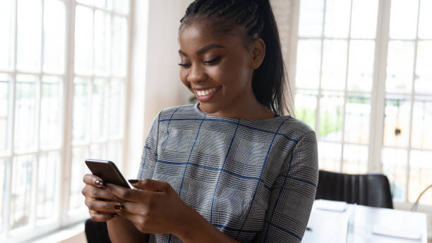 istock Smiling african American female employee using modern smartphone 1263380094