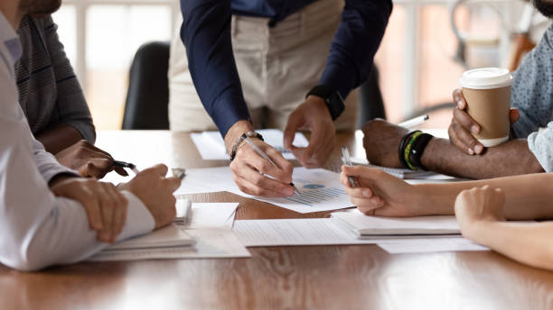 istock Multiethnic businesspeople brainstorm discussing paperwork at briefing 1263380518