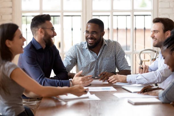 istock Smiling diverse millennial colleagues have fun at meeting 1263380535