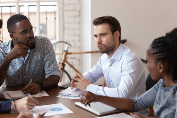 istock Focused multinational colleagues discuss ideas at meeting 1263380538