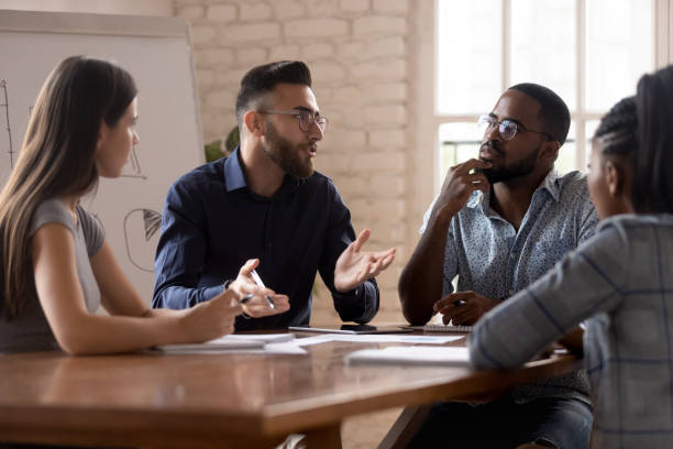 istock Thoughtful millennial diverse colleagues discuss ideas at briefing 1263380542