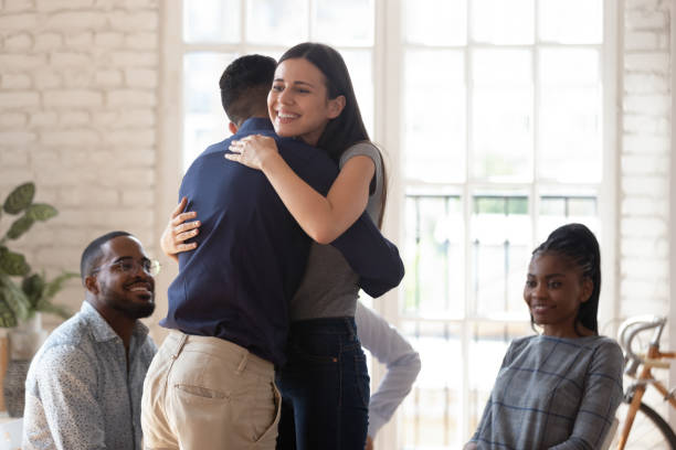 abbraccio felice uomo e donna che mostra supporto durante la sessione di terapia - couple dependency standing men foto e immagini stock