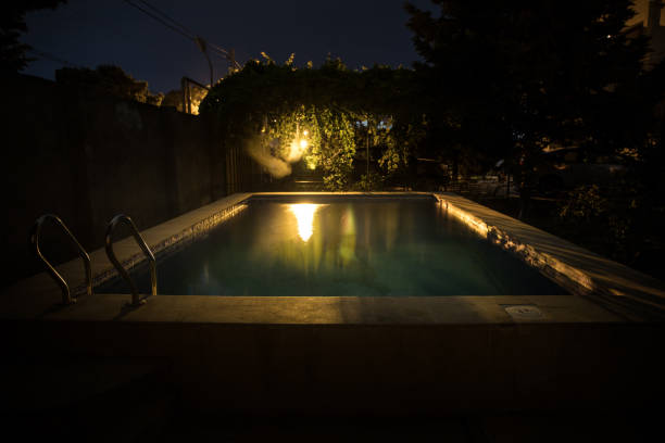 istock Pool and waterfall at night - vacation background. Colorful light decoration. Freezelight 1263381140