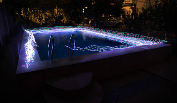 istock Pool and waterfall at night - vacation background. Colorful light decoration. Freezelight 1263381155