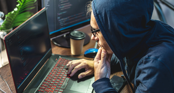 Hacker Dalam Kerudung Memprogram Kode Virus Pada Laptop Konsep Penipuan Hacker Dalam Kerudung Memprogram Kode Virus Pada Laptop Konsep Penipuan