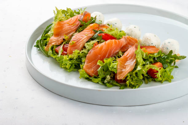 istock Salmon salad with cheese balls on a white plate 1263390812