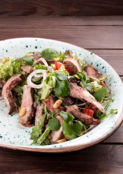 istock Salad with roast beef and cherry tomatoes on a wooden background 1263390985