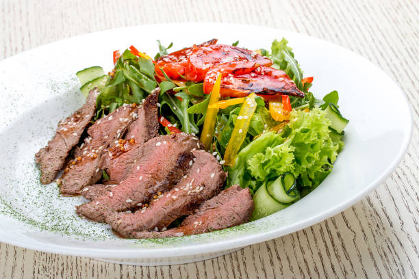 istock Salad with roast beef and sun-dried tomatoes on white background 1263393193