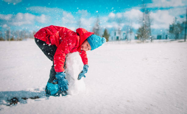 istock happy kid enjoy building from snow in nature 1263398839